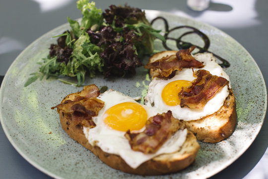 Bacon and fried eggs on toast with  lettuce decoction