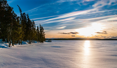 sunset over frozen lake with pearlescnet clouds