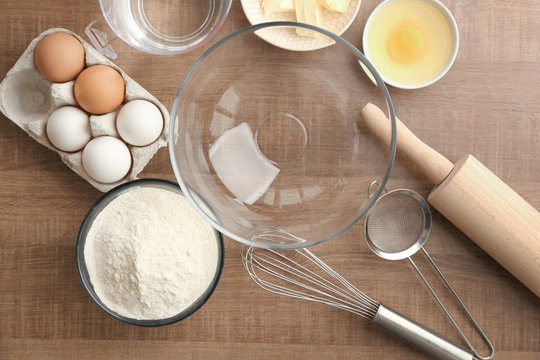 Bowl with flour and ingredients for dough on table