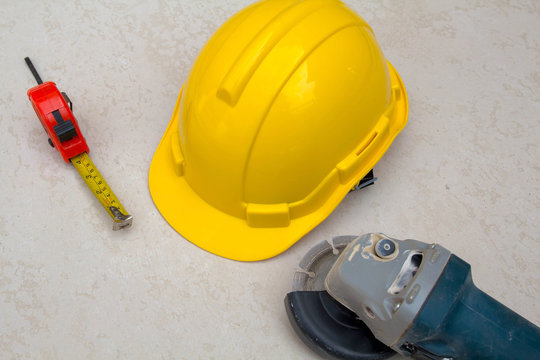 yellow hardhat , measurement tape and cutter electric saw