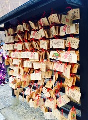 Traditional asian wood plates with wishes written in Japanese characters to receive luck - inside Kiyomizu Dera, a buddhist temple of the Heian period (UNESCO World Heritage Site in Kyoto Japan)