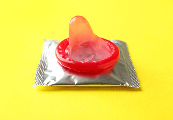 Open and wrapped condoms on color background. Safe sex concept