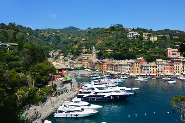 Fototapeta na wymiar PORTOFINO, ITALY - JUNE 13, 2017: The beautiful Portofino with colorful houses and villas, luxury yachts and boats in little bay harbor. Liguria, Italy, Europe 