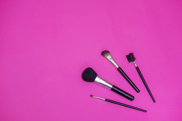 Make-up brushes on a bright pink background. Place to insert text.