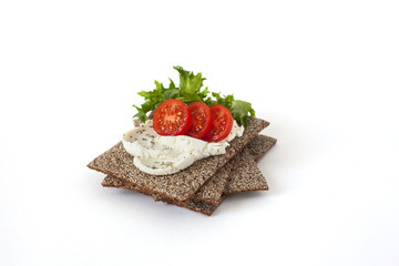 Healthy snack from wholegrain rye crispbreads crackers with Cherry tomatoes, salad and goat cheese