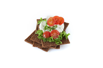 Healthy snack from wholegrain rye crispbreads crackers with Cherry tomatoes, salad and goat cheese