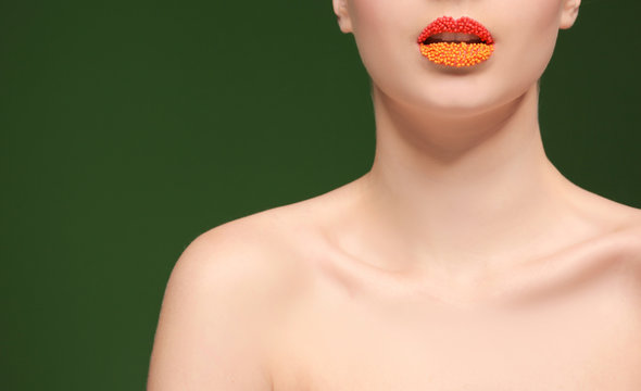 Woman with creative makeup on color background