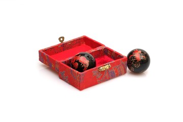 Chinese massage balls in a silk box on white background