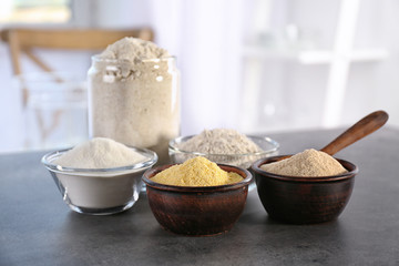 Bowls with different types of flour on table