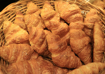 Basket of fresh baked almond croissant pastries in the bakery