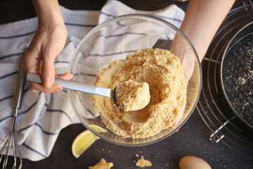 Woman preparing dough for cheese cake in kitchen