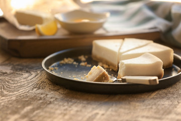 Tray with cheese cake pieces and spoon on kitchen table