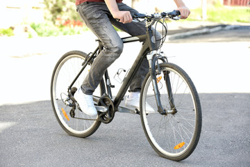Fototapeta na wymiar Young man riding bicycle outdoors on sunny day