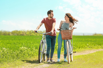 Fototapeta premium Happy young couple with bicycles in countryside