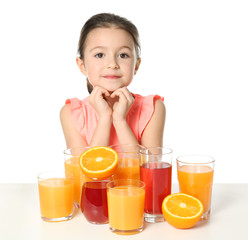 Cute little girl with glasses of different juice on white background