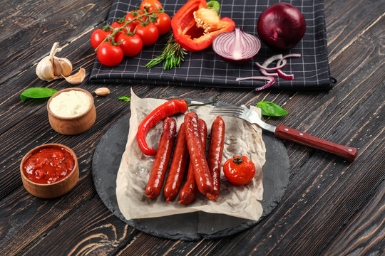 Composition with yummy grilled sausages on wooden table