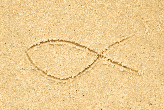 Jesus fish symbol drawing in sand