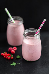 Two glasses with berry pink smoothies with currant and cranberry, selective focus