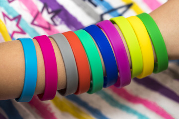 Rubber bands on hand. Girls hand with bracelets made of rubber bands. Rainbow loom colored rubber...