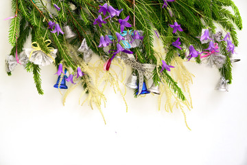 christmass tree brunches decorated with a bells and bell flowers in a row above, copy space for your text at the bottom. new year and christmas conceptual greeting card.