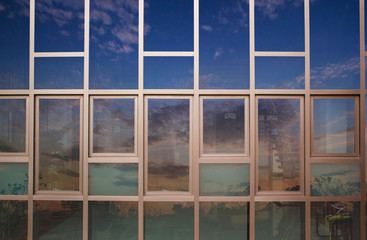 Reflection sky and clouds on building windows glass. Mixed media.