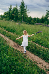 Child runs and jumps on a path in the field