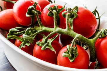 Cherry tomatoes in white bowl.
