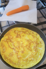 omelette in pan with near a carrot