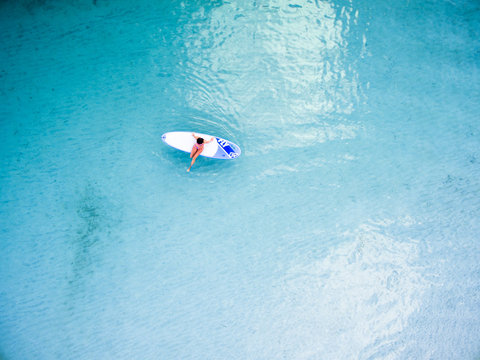 Aerial view of surfer surfing in ocean
