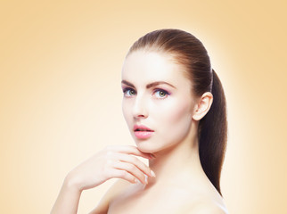 Portrait of young, beautiful and healthy woman: over yellow background. Healthcare, spa, makeup and face lifting concept.