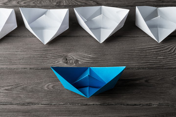 Business leadership concept with white and color paper boats on 