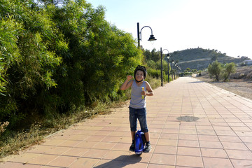 El niño con el casco esta paseando en el parque con la rueda Monowheel..  scooter electrico © Olga