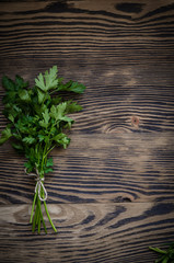 Obraz premium Fresh parsley on wood background.