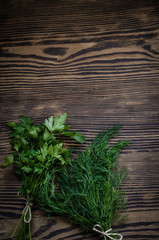 Fresh green dill and parsley herbs on rustic wooden table. Top view with copy space