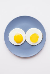 two beautiful eggs on a plate and a yellow napkin