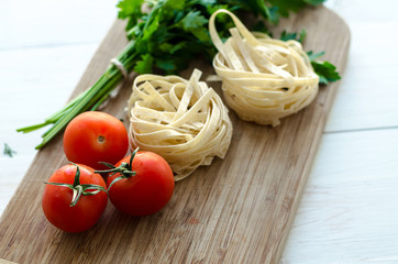 Ingredients for cooking Italian pasta - spaghetti, tomatoes, basil and garlic.