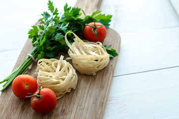 Ingredients for cooking Italian pasta - spaghetti, tomatoes, basil and garlic.