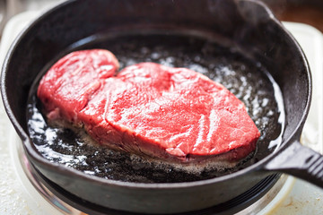Raw angus steak fried on vegetable oil, iron cast