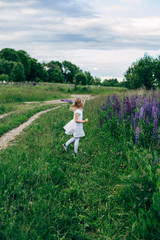 Child runs and jumps on a path in the field