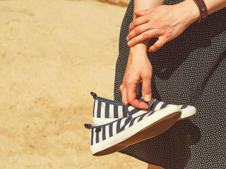 Female hands with summer shoes.