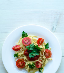 Tagliatelle pasta with tomato sauce decorated with basil leafs