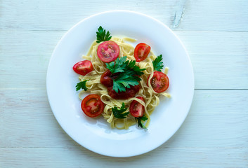 Tagliatelle pasta with tomato sauce decorated with basil leafs