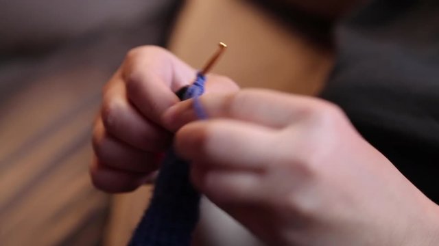 Woman chrocheting wool thread  background
