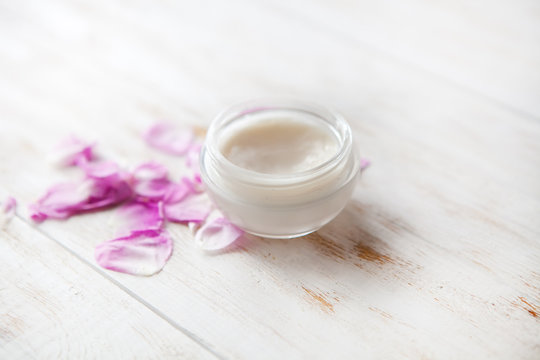 Tired skin cosmetic cream facial skincare medical treatment therapy .face cream with rose petals on white background