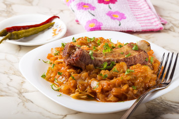 Cabbage stew with Smoked Pork Ribs Served in white plate with pickled chili peppers