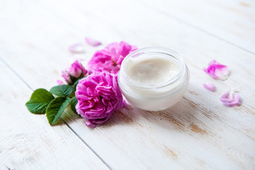 Obraz na płótnie Canvas pot of moisturizing face cream and beautiful pink roses