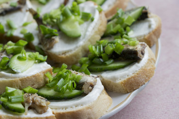 Sprats sandwiches with cucumber and green onion.Fish sandwiches