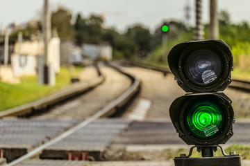 Routing traffic light with a green signal on railway. Railway crossing with semaphore. Permissive Motion. Limited depth of field.