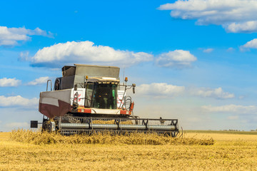Combine harvester is working in the field for harvesting. Agricultural work on a sunny day.