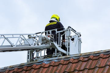 Freiwillige Feuerwehr beim Einsatz mit der Drehleiter über den Dächern der Stadt